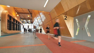 The double height foyer acts as a internal street and also contains a strength and conditioning area, recovery rooms, consultation spaces, change rooms and, at the upper level, teaching, learning and staffing areas